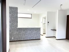 18帖の広さを活かした開放的なリビングです。グレーのアクセントウォールが空間を引き締め、お好みの家具を配置することで自分たちらしい居心地の良い場所を作れます。