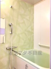 柔らかなグリーンのパネルがアクセントになった、清潔感あふれるバスルームです。ゆったりとした浴槽で、一日の疲れを癒すリラックスタイムを過ごせます。水はけの良い床材で、日々のお掃除も楽々です。